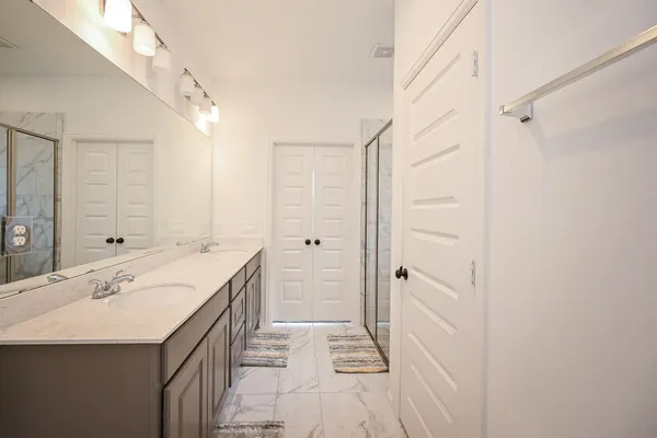 a bathroom with a sink a mirror and a shower