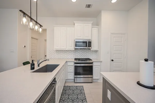 a kitchen with a stove a sink and a refrigerator