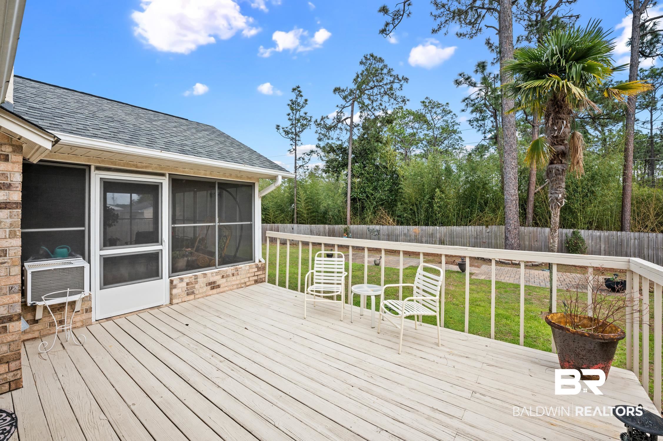 2553 Santa Rosa Drive Lillian, AL 36549 - Photo 6 of 51 Wooden deck featuring a sunroom, a fenced backyard, and a yard