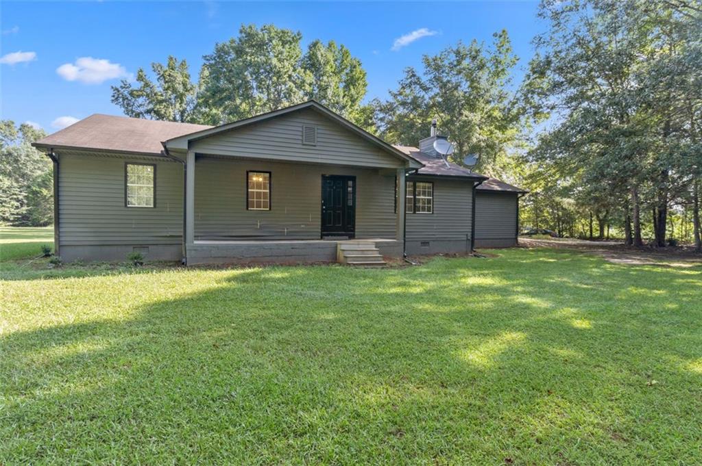 1546 Bucksnort Road Jackson, GA 30233 - Photo 1 of 1 a brick house next to a yard with large trees
