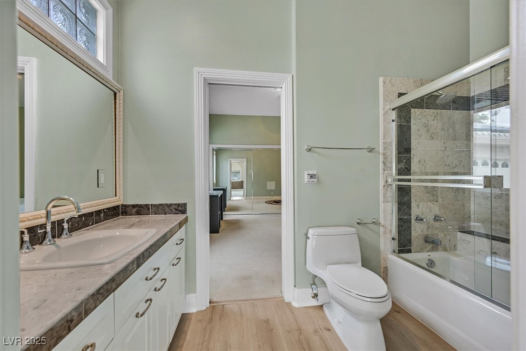 3372 Westwind Road Las Vegas, NV 89146 - Photo 29 of 39 Full bathroom with combined bath / shower with glass door, light wood finished floors, and vanity