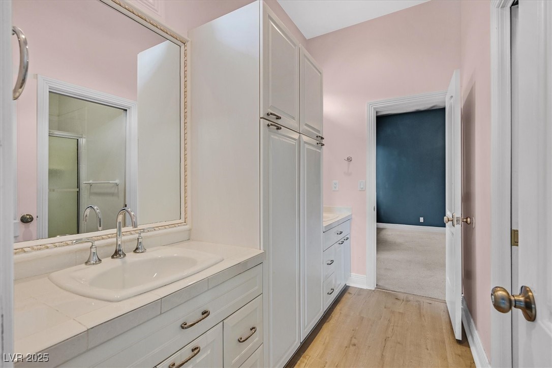 3372 Westwind Road Las Vegas, NV 89146 - Photo 6 of 39 Bathroom with two vanities, light wood-type flooring, and a stall shower