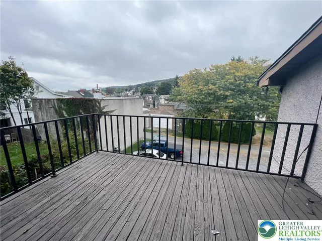 a balcony with wooden floor and fence