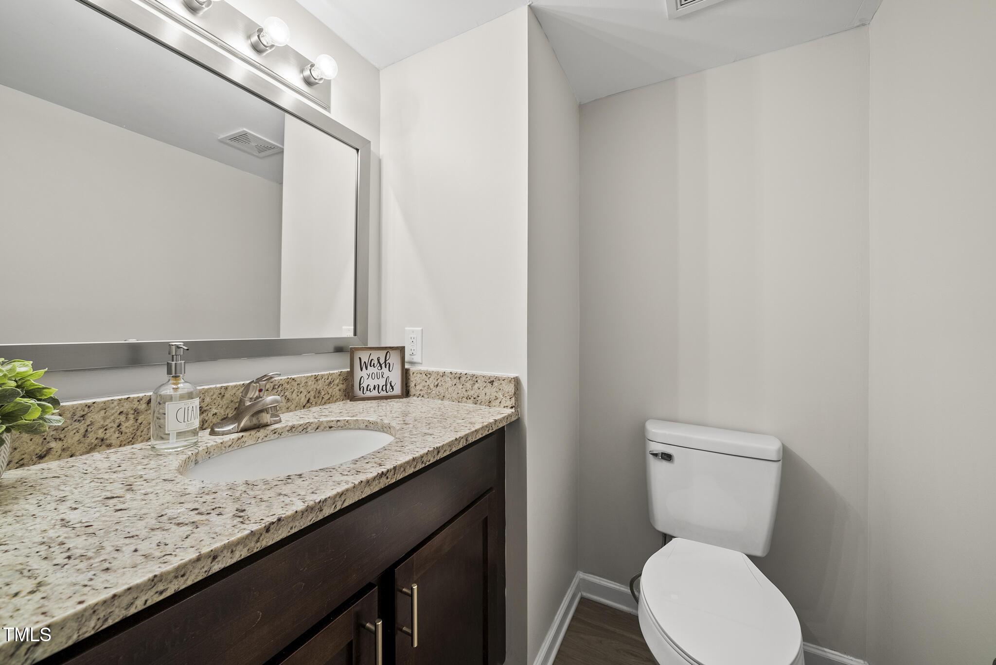 710 Powell Drive, Unit F Raleigh, NC 27606 - Photo 15 of 32 a bathroom with a granite countertop toilet sink and mirror