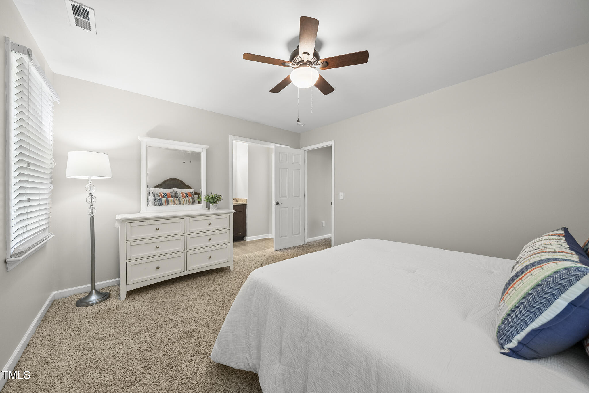 710 Powell Drive, Unit F Raleigh, NC 27606 - Photo 18 of 32 a bedroom with a bed and ceiling fan