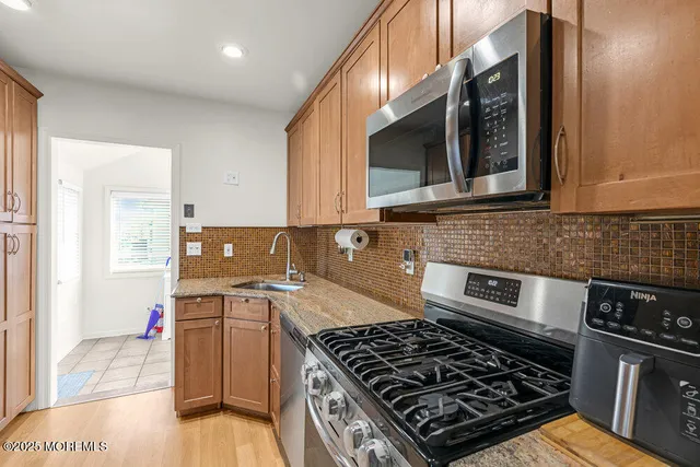 a kitchen with stainless steel appliances granite countertop a sink stove and cabinets