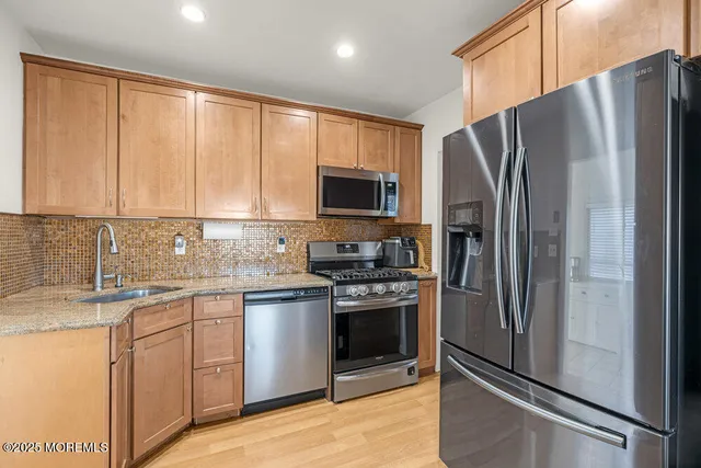 a kitchen with stainless steel appliances granite countertop a refrigerator stove and sink