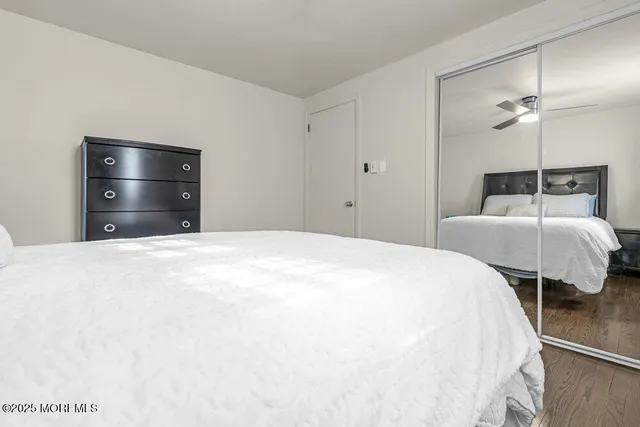 a view of a big house with a big yard potted plants and large tree