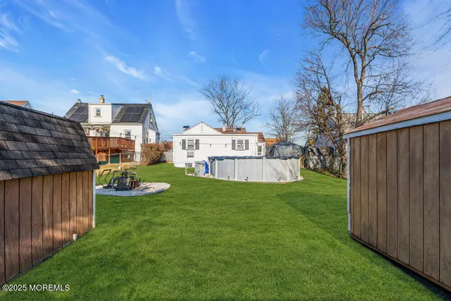 a view of a house with backyard and sitting area