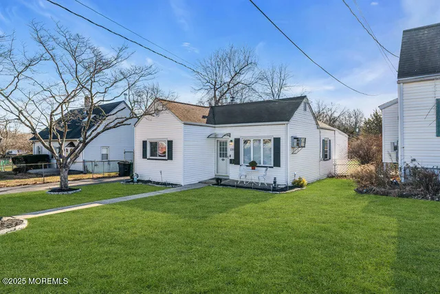 a front view of a house with a garden and trees