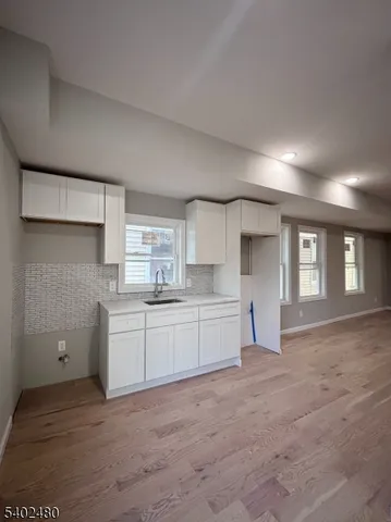 a large white kitchen with kitchen island a sink dishwasher and a stove