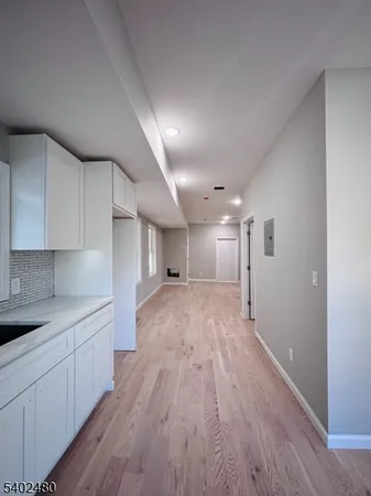 a view of a kitchen with a sink and wooden floor