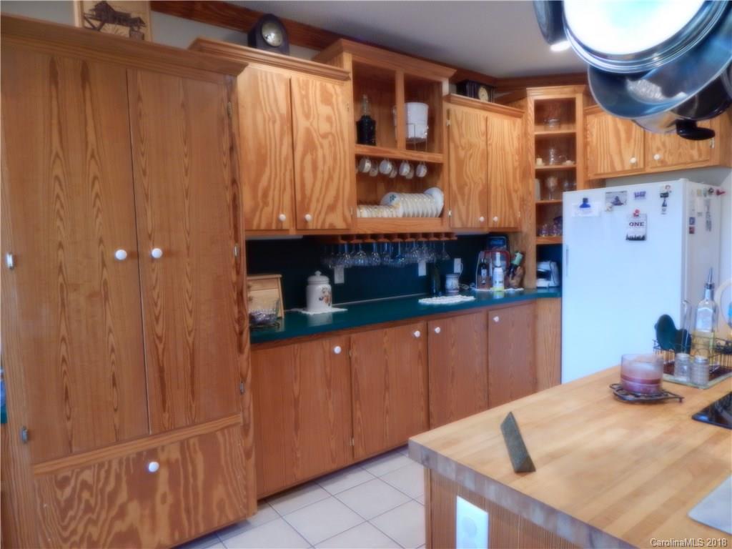 6026 Fish Road Marshville, NC 28103 - Photo 20 of 45 a kitchen with stainless steel appliances granite countertop a sink a stove and wooden cabinets