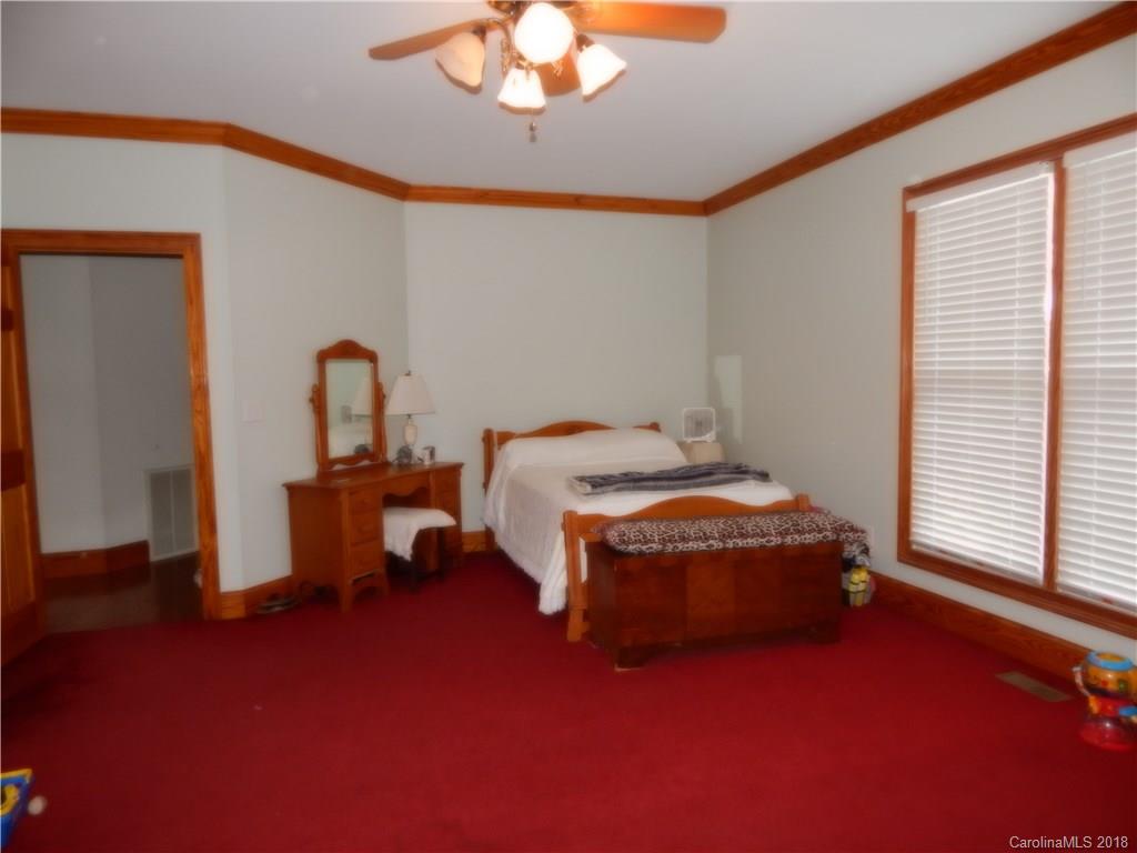 6026 Fish Road Marshville, NC 28103 - Photo 26 of 45 a bedroom with a bed and a chandelier