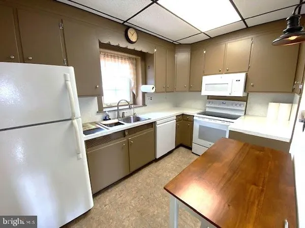 a kitchen with a sink a refrigerator and window