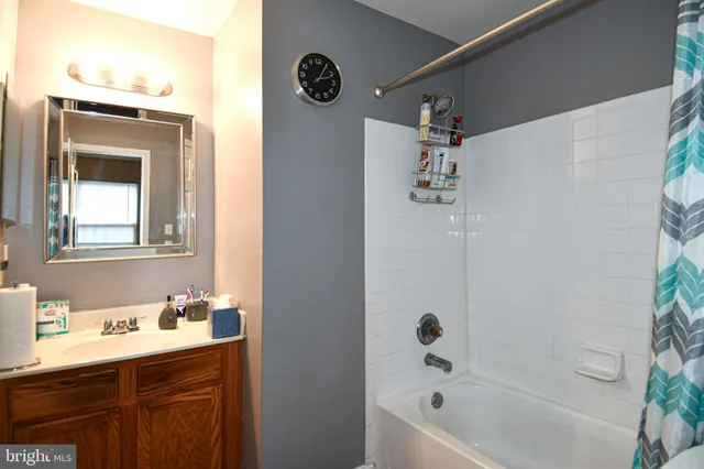 a bathroom with a tub sink and mirror