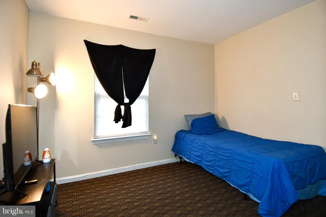 a bed sitting in a bedroom next to a window