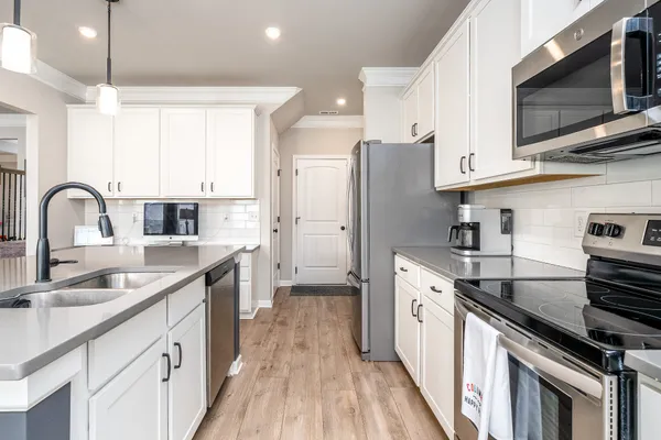 a kitchen with stainless steel appliances granite countertop a sink stove and refrigerator