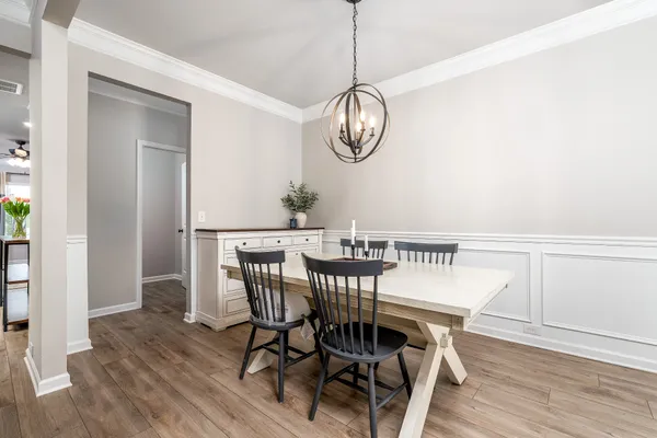 a view of a dining room with furniture wooden floor and chandelier