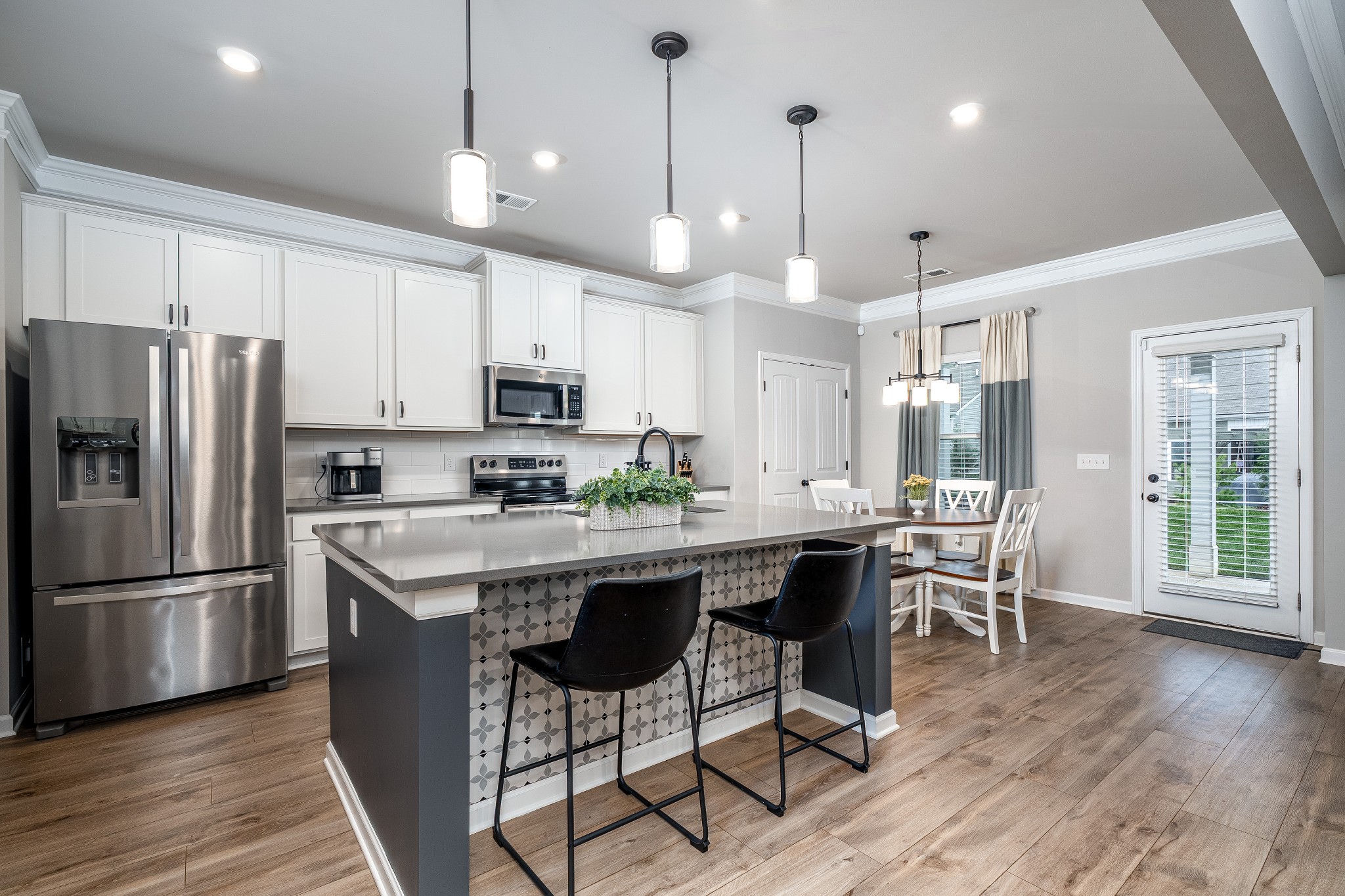 2991 Timewinder Way Columbia, TN 38401 - Photo 6 of 33 a kitchen with stainless steel appliances granite countertop a dining table chairs refrigerator and microwave