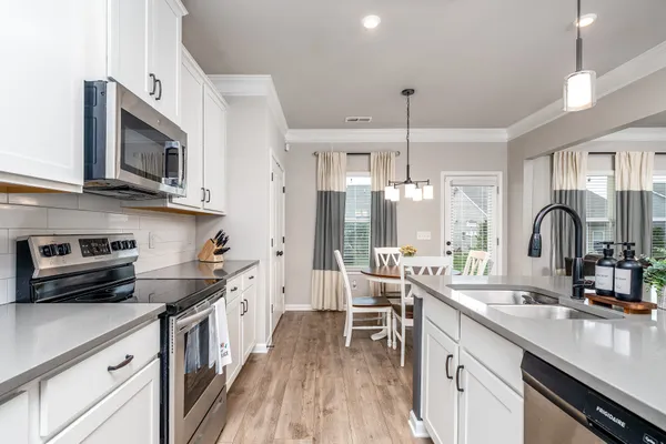 a kitchen that has a lot of cabinets and wooden floor