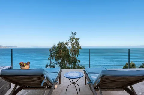 a view of a chairs and table in the balcony