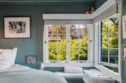 a bed sitting in a bedroom next to a window