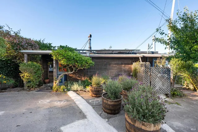 a view of a patio with table and chairs potted plants and large tree