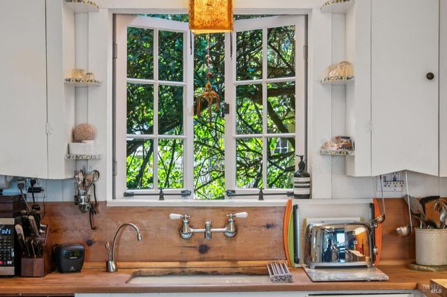 a kitchen with stainless steel appliances a stove and white cabinets