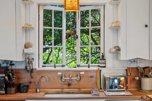 a kitchen with stainless steel appliances a stove and white cabinets