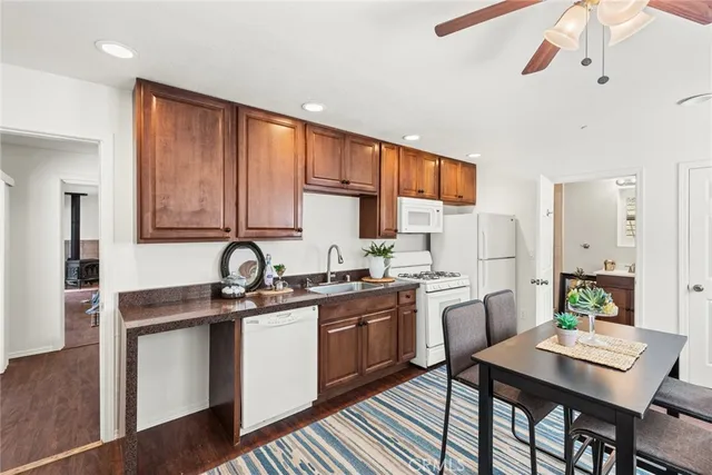 a kitchen with stainless steel appliances granite countertop a stove a sink dishwasher and a refrigerator with wooden floor