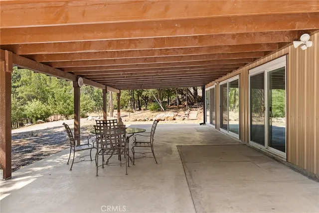 a view of a patio with table and chairs and floor to ceiling window