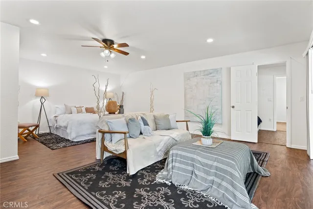 a spacious bedroom with a bed a couch and chandelier