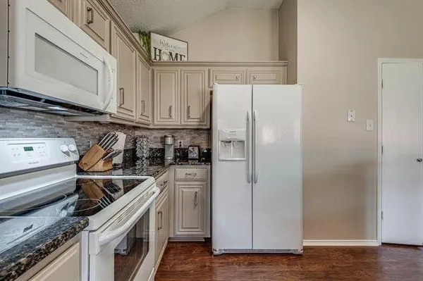 a kitchen with a refrigerator sink and cabinets