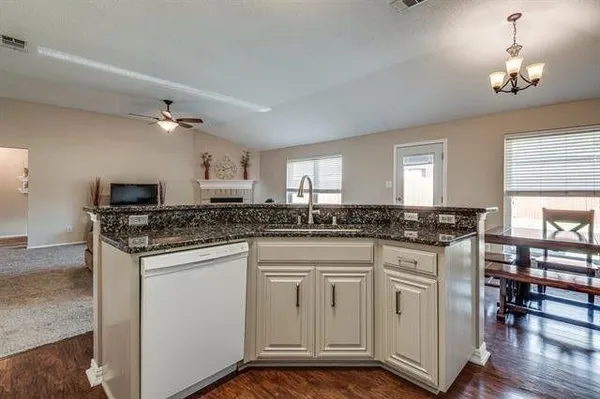 a kitchen with cabinets and chairs