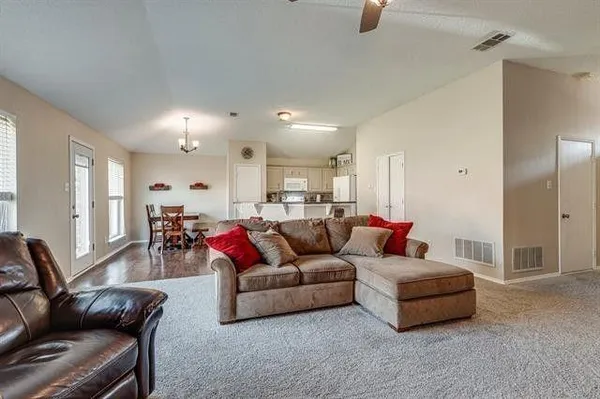 a living room with furniture and a wooden floor