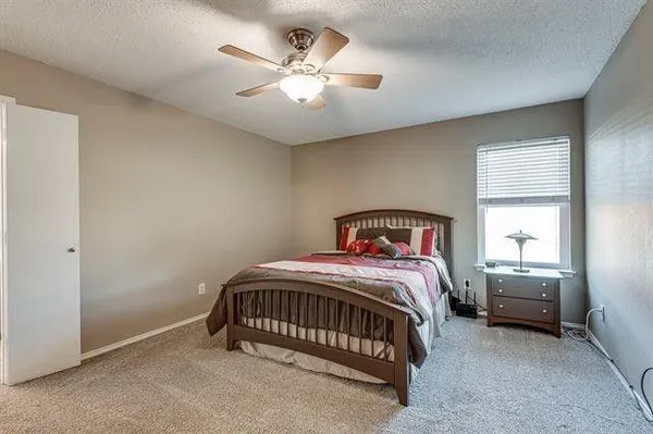 a bedroom with a bed a window and a chandelier