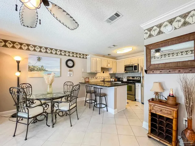 a kitchen with stainless steel appliances kitchen island granite countertop a table and chairs in it