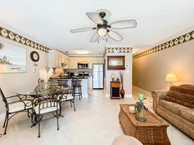 a living room with furniture kitchen view and a chandelier