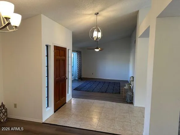 an empty room with wooden floor windows and fan