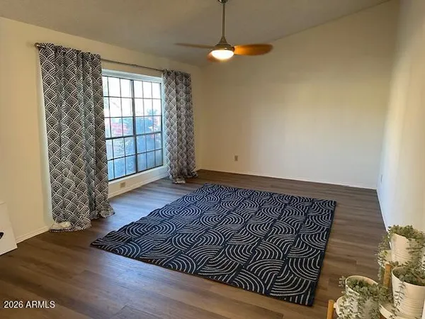 a view of a livingroom with wooden floor and window