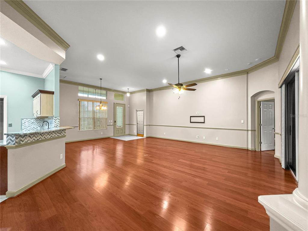 8045 Waterbury Way Mount Dora, FL 32757 - Photo 14 of 56 a view of an empty room with window and wooden floor