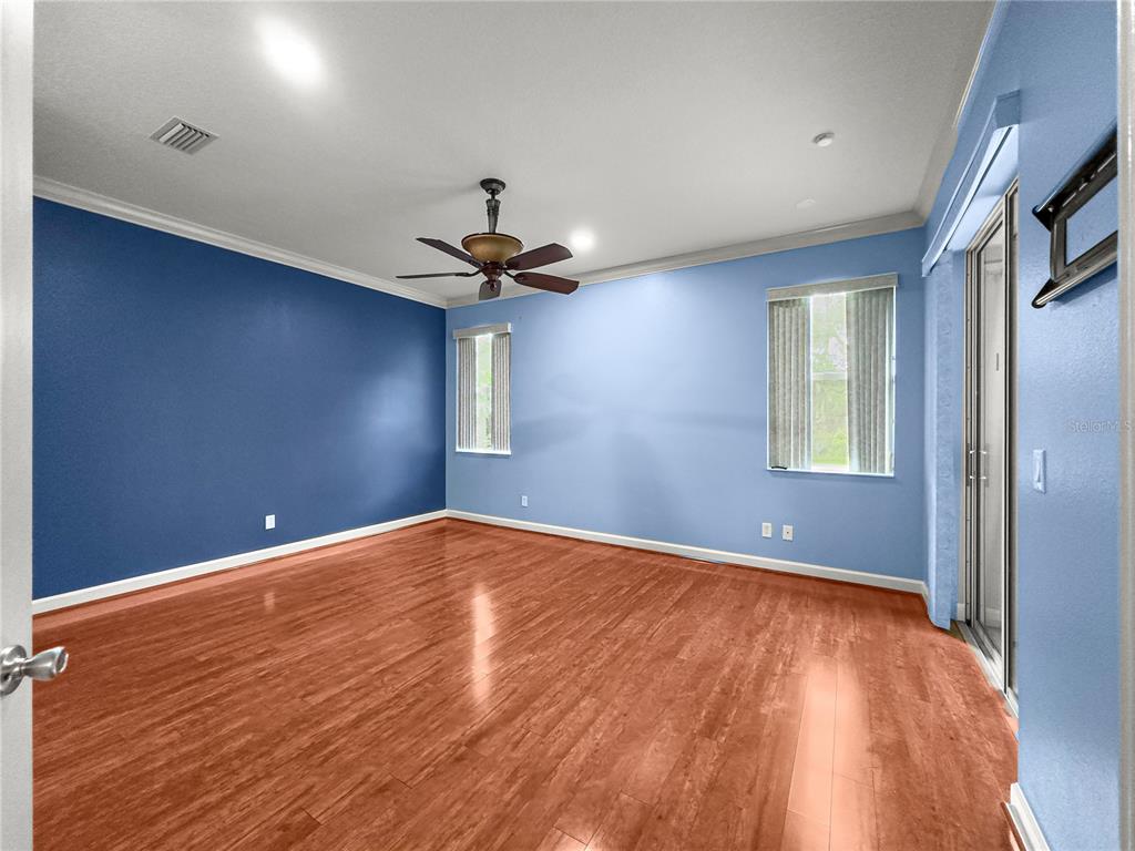 8045 Waterbury Way Mount Dora, FL 32757 - Photo 21 of 56 a view of empty room with wooden floor and fan