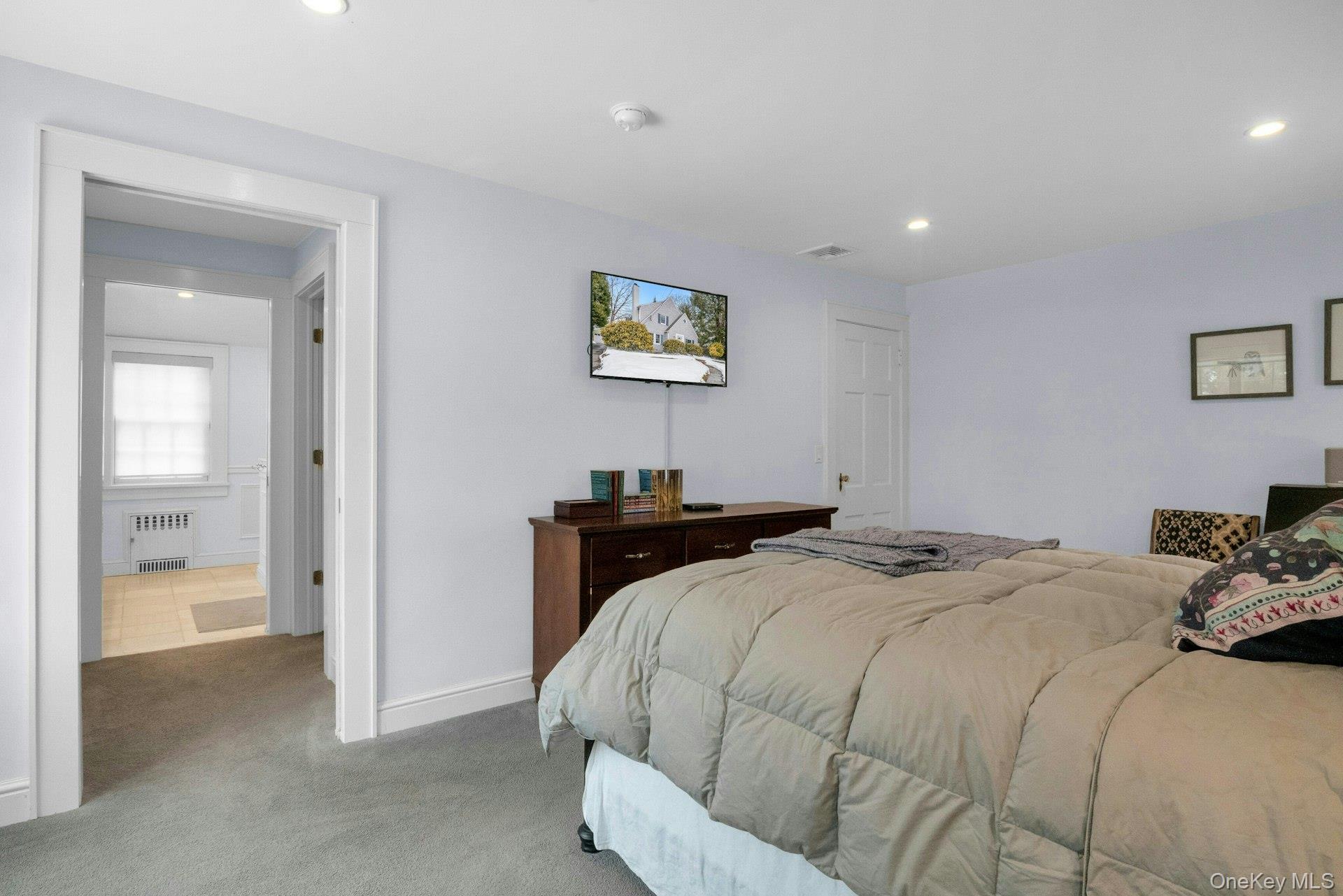 25 Maple Road Briarcliff Manor, NY 10510 - Photo 23 of 48 View from Primary BR sleeping area to an open pocket door to reveal the dressing area/closet area heading towards the Primary Bathroom. Wall-mounted TV included.
