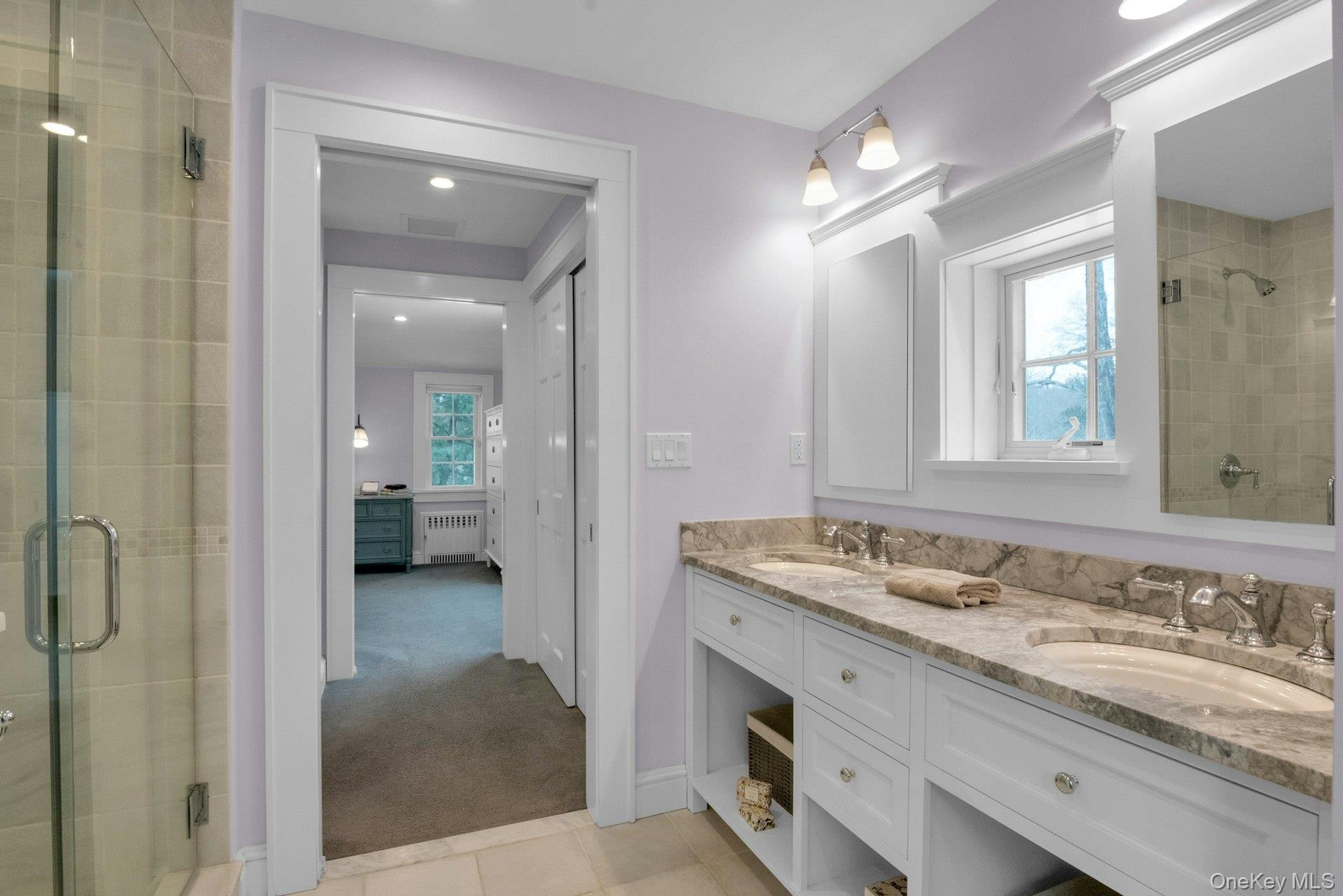 25 Maple Road Briarcliff Manor, NY 10510 - Photo 26 of 48 Another pocket door leads into this pristine Primary Bathroom with tumbled marble floors, double sink marble vanity with two medicine chests & window above.