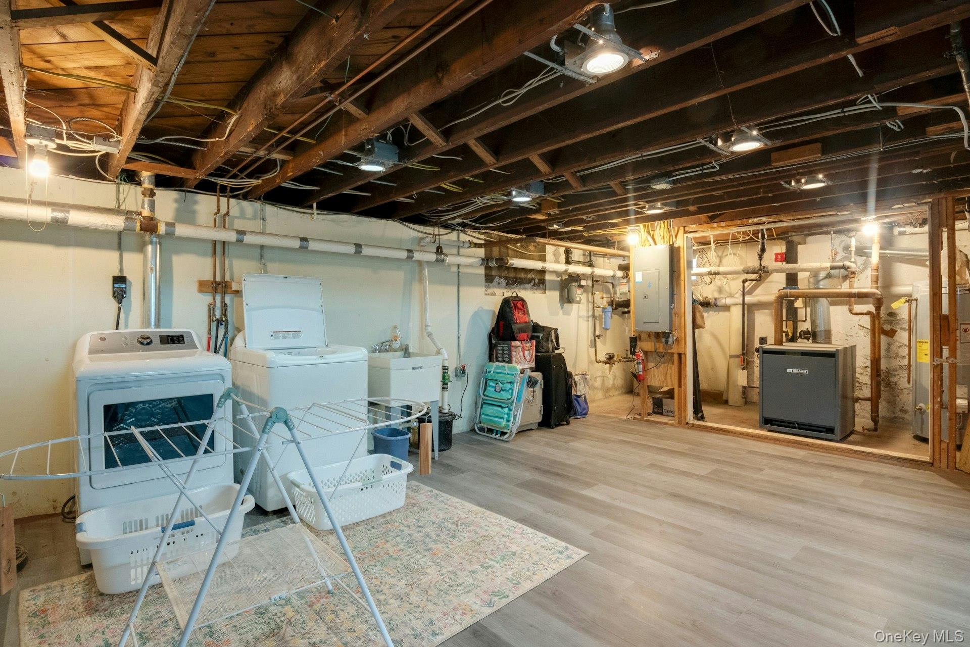 25 Maple Road Briarcliff Manor, NY 10510 - Photo 36 of 48 Laundry area, mechanicals & loads of storage in this completely open, full Basement with new vinyl flooring, a Connecticut Basement Waterproofing System (checked annually). Also a door out to steps up towards driveway.
