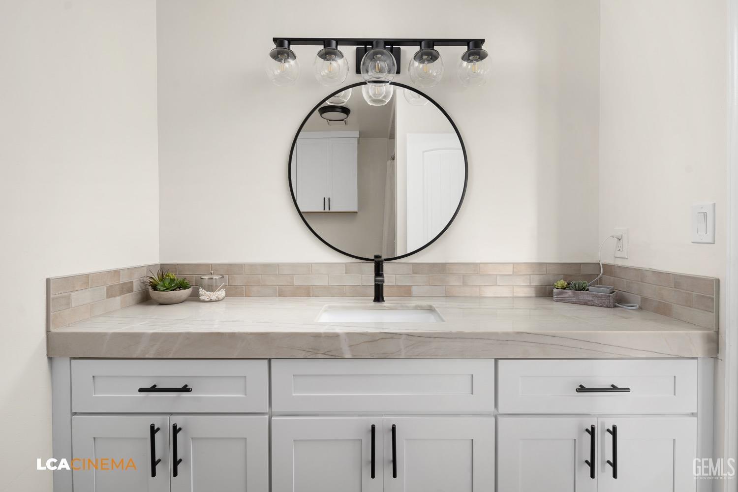 Undisclosed Address Bakersfield, CA 93312 - Photo 19 of 28 a bathroom with a granite countertop sink and a mirror