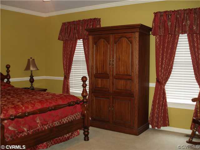 4035 Doe Run Road Hopewell, VA 23860 - Photo 8 of 12 a bed sitting in a bedroom next to a wooden door