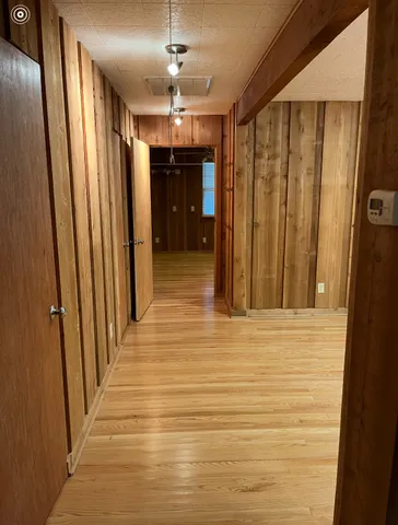 a view of a hallway with wooden floor and staircase