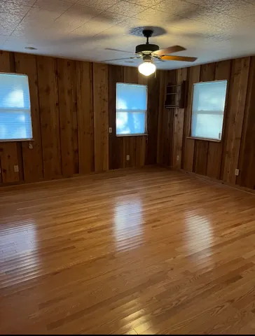 a view of a livingroom with wooden floor and a ceiling fan